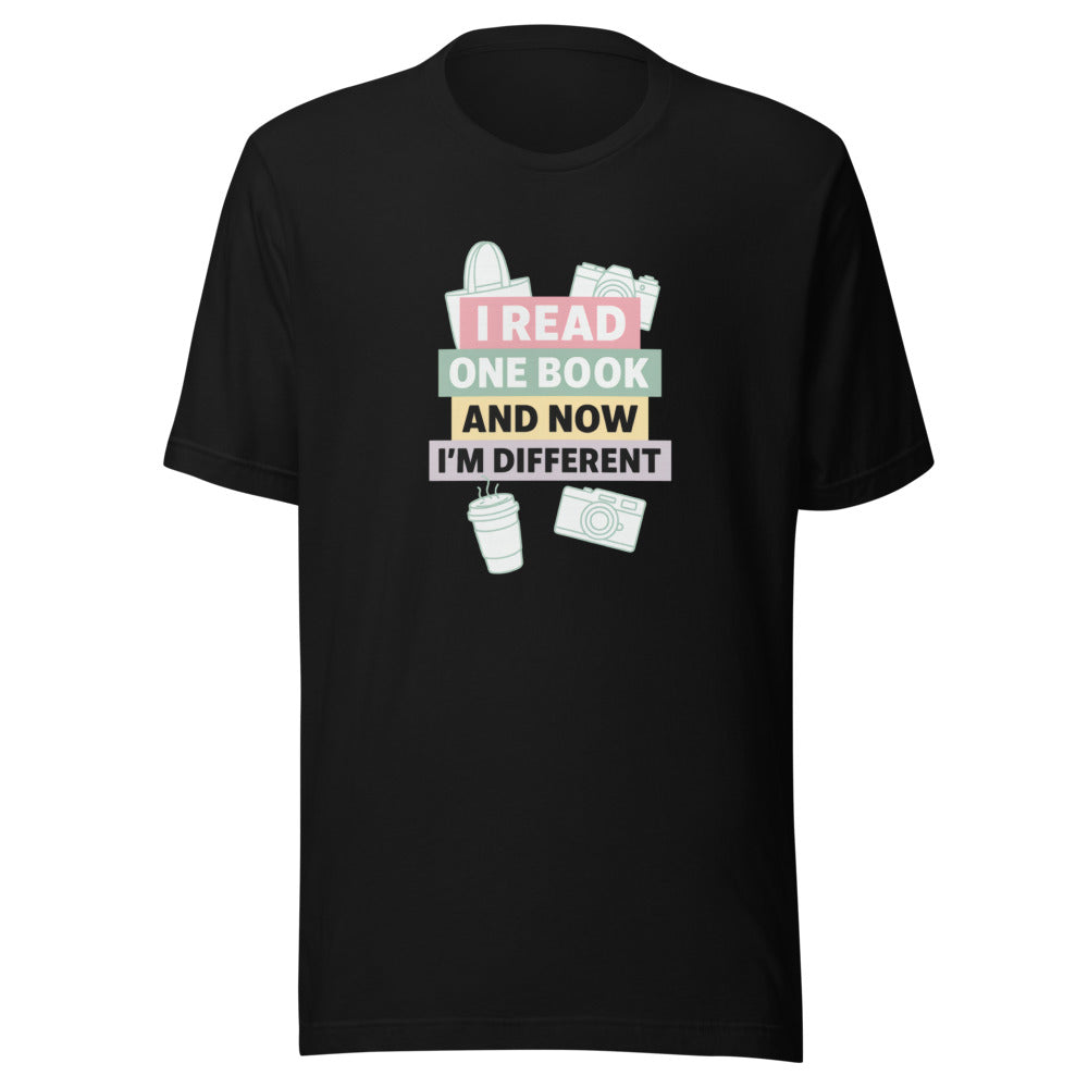 illustration of a book, coffee cup, and camera with text 'I Read One Book and Now I'm Different' Tee front view — Wandering With Pride